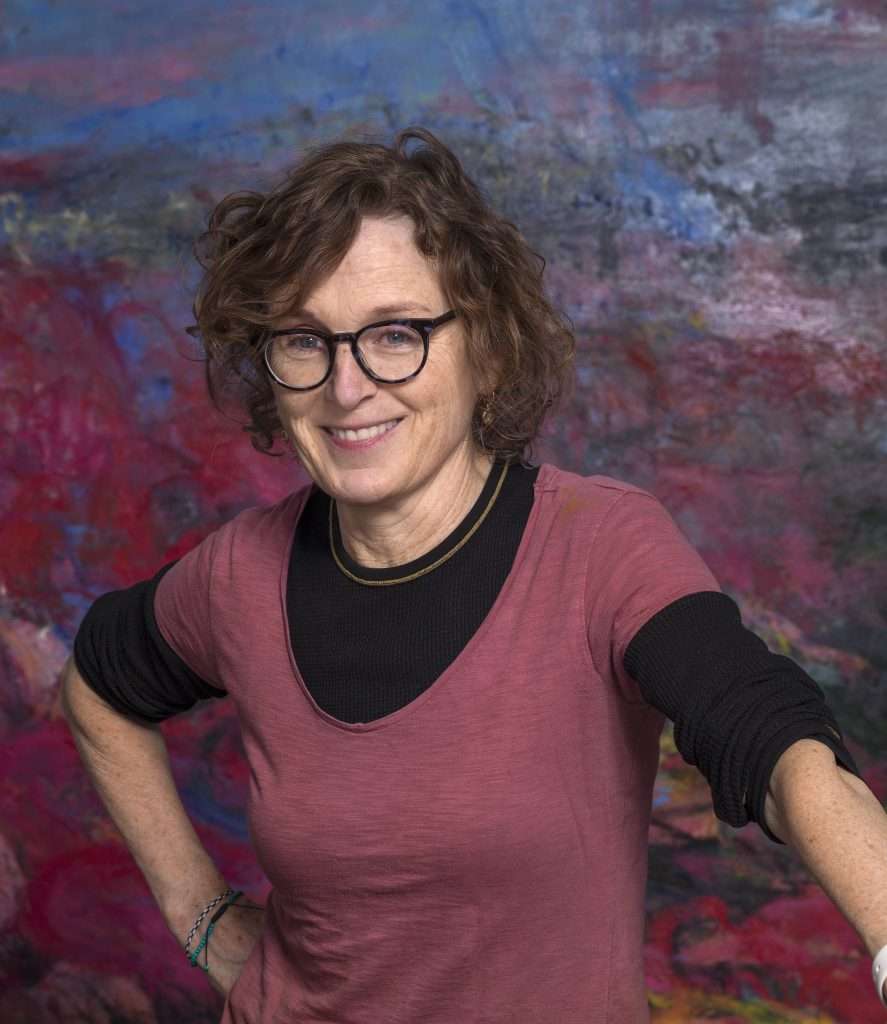 A Portrait of artist Helen O' Toole, smiling over a purple and blue background.