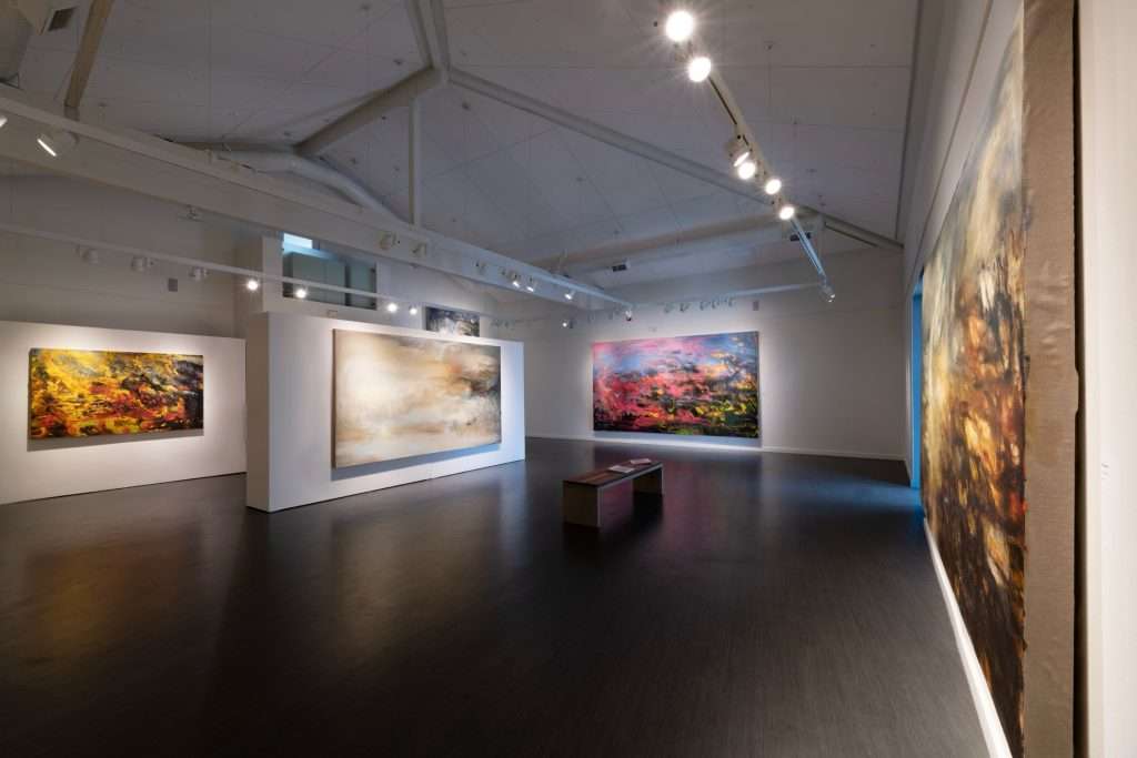 A gallery showing an exhibition of a series of paintings by Helen O' Toole. The paintings are big and very colourful over the white walls.