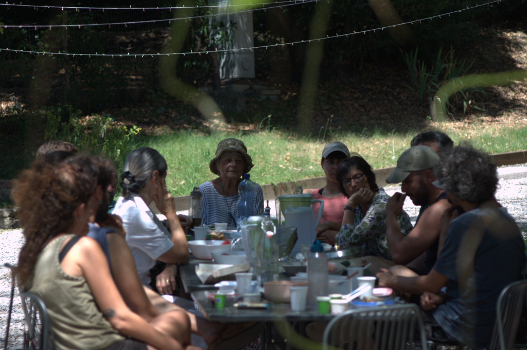 A group of people having a relaxed Permapotluck outside the Siena Art