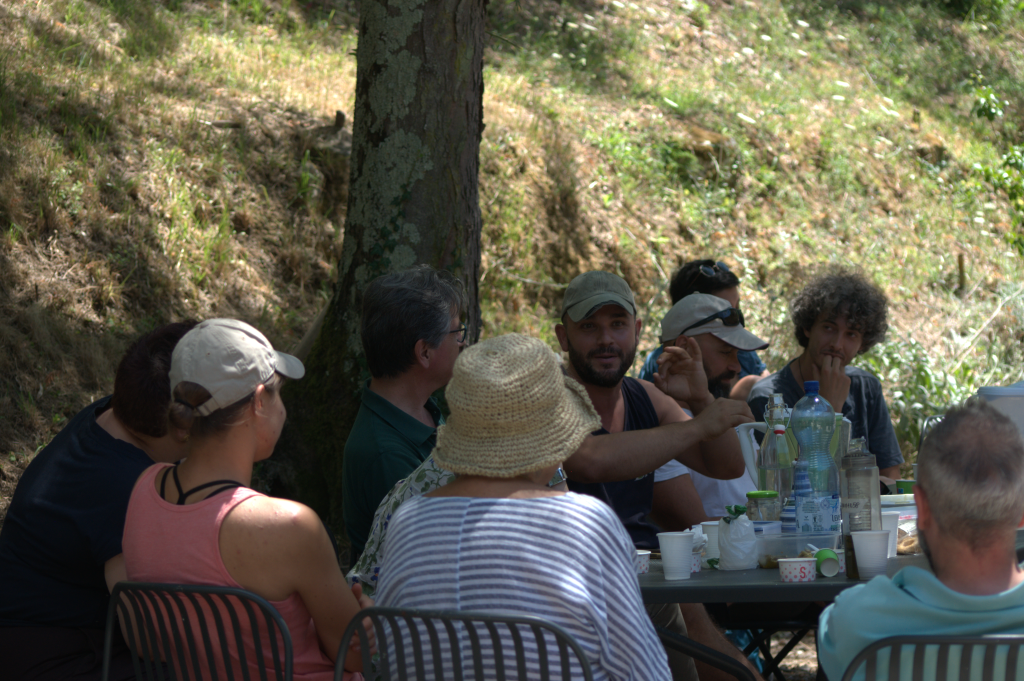 A group of people having a relaxed Permapotluck outside the Siena Art Institute
