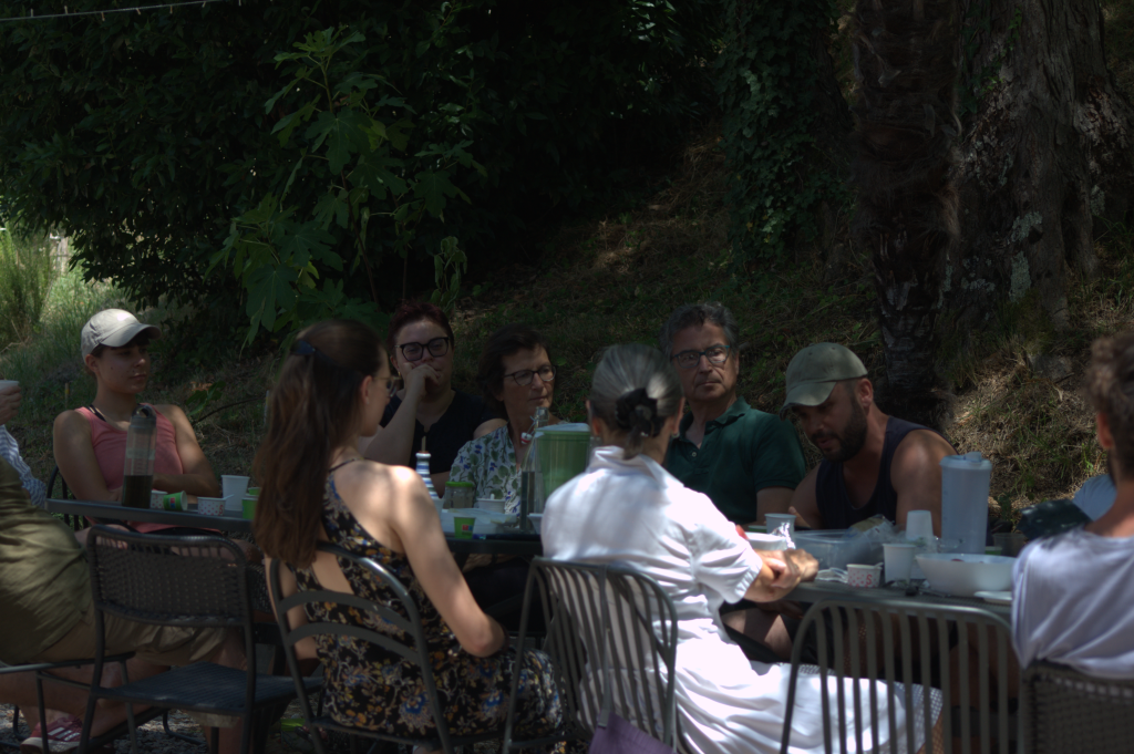 A group of people having a relaxed Permapotluck outside the Siena Art