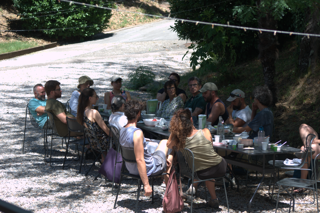 A group of people having a relaxed Permapotluck outside the Siena Art