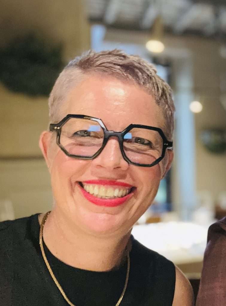 A smiling portrait of artist Kirsten Stromberg